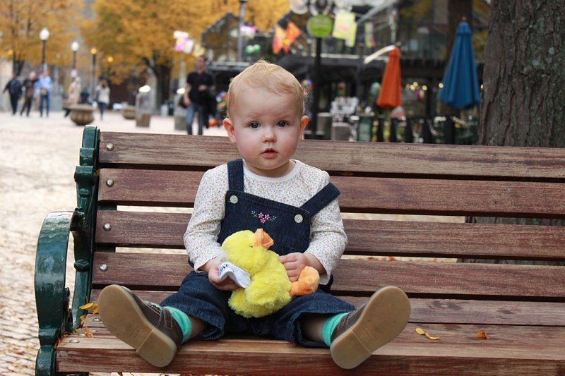 IMG_3742.jpg - Camille sitting on a bench at Quincy Market enjoying her new Boston Duck